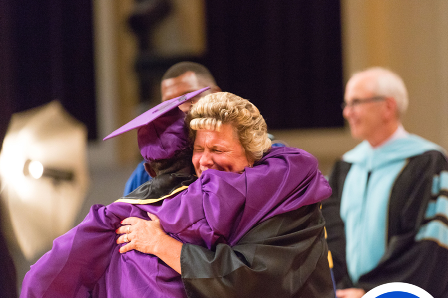 East principal and graduate hugging