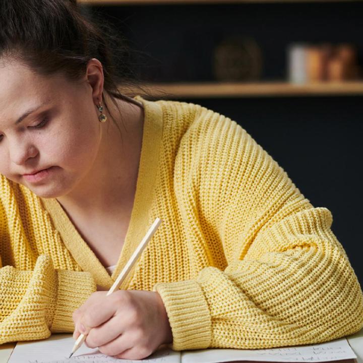 Student with down syndrome taking notes