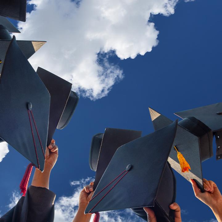 High school students holding up graduation caps.