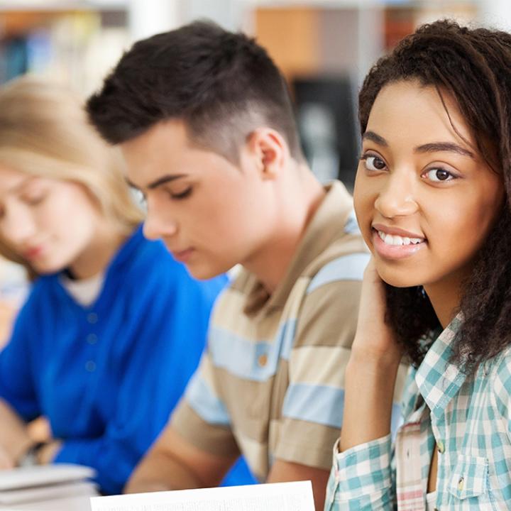 Three students sitting in a classroom
