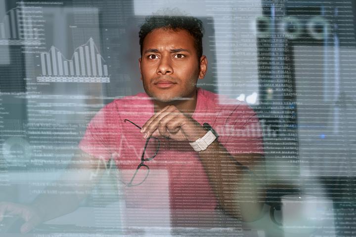 Man looking at computer screen with charts and graphs